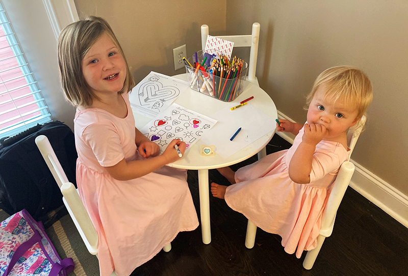 Poppy and Goldie drawing at the table.