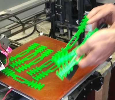 hands breaking apart 3d printed pieces